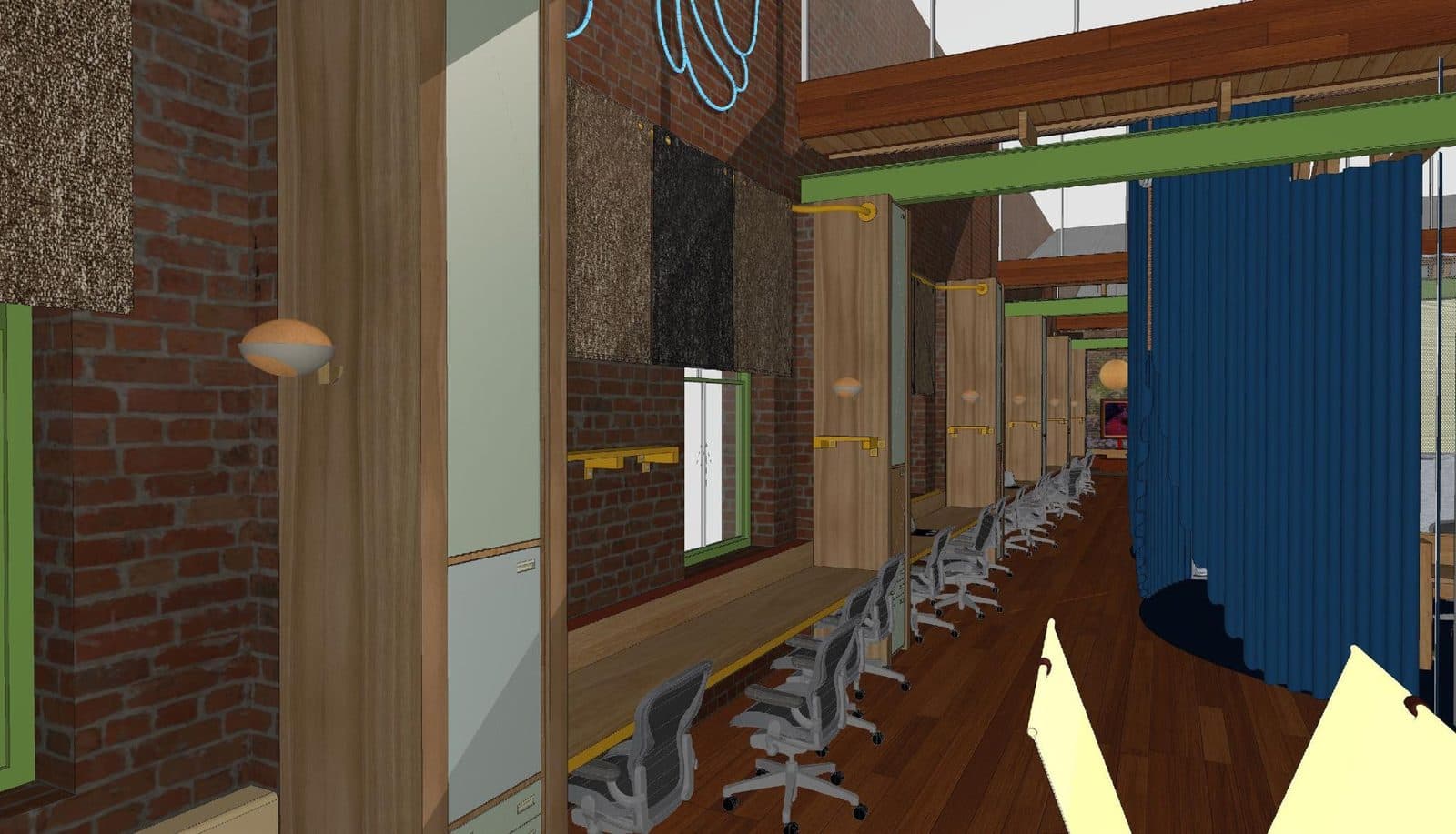 The flex desk corridor at MASS, desks along the brick wall